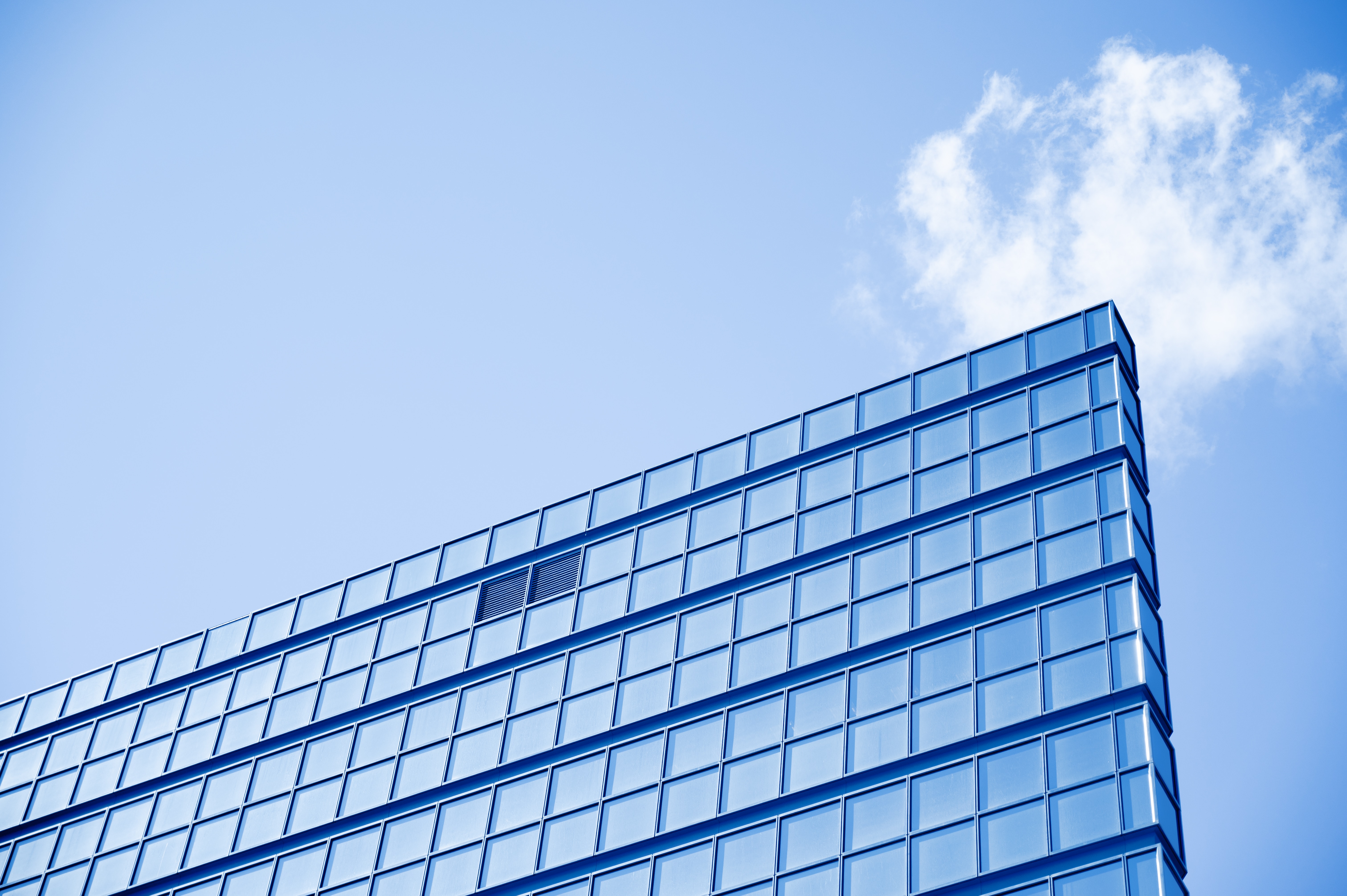 Decorative Image of a blue building in front of a blue sky with some white clouds